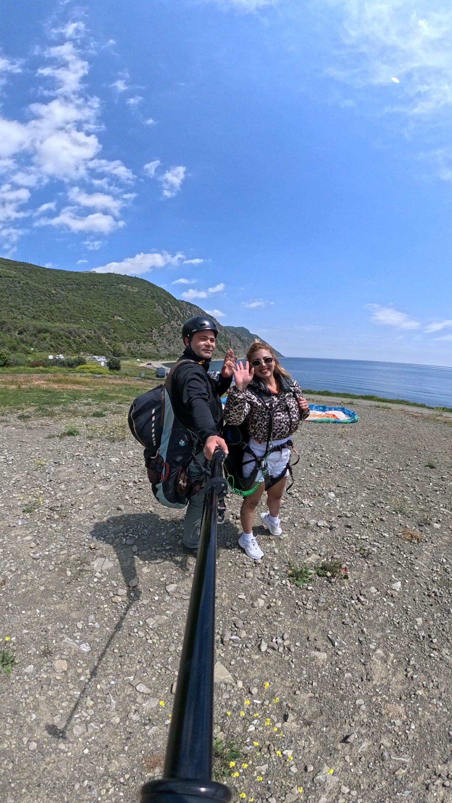 Uçmakdere'de yamaç paraşütü yapan iki kişi, deniz ve doğa manzarasıyla birlikte.
